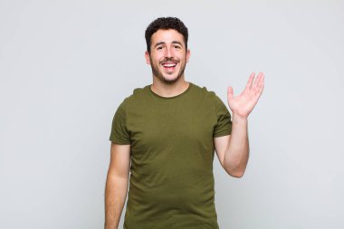 Genç adam mutlu, şaşırmış ve neşeli hissediyor, pozitif bir tavırla gülümsüyor, bir çözüm ya da fikir buluyor.