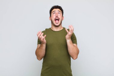 Genç adam umutsuz ve hayal kırıklığına uğramış görünüyor, stresli, mutsuz ve sinirli, bağırıyor ve çığlık atıyor.