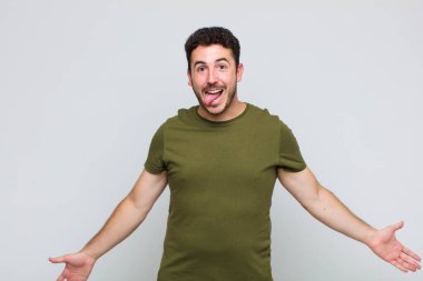 Genç adam şapşal ve komik görünüyor. Şaşı bakışlı, şakacı ve şakacı.