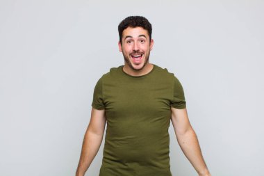 Genç adam mutlu ve hoş bir şekilde şaşırmış görünüyor. Büyülenmiş ve şok olmuş bir ifadeyle heyecanlanıyor.