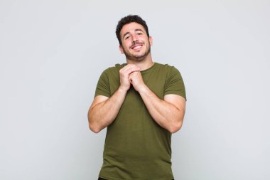 Genç adam aşık ve sevimli görünüyor. Sevimli ve mutlu. Romantik bir şekilde gülümsüyor.