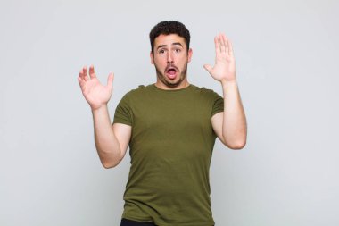 Genç adam elleri havada bağırıyor, öfkeli, sinirli, stresli ve üzgün hissediyor.