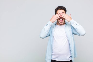 Genç adam gülümsüyor ve mutlu hissediyor, iki eliyle gözlerini kapatıyor ve inanılmaz bir sürpriz bekliyor.