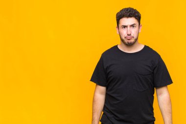 Genç adam üzgün ve mızmızlanıyor, mutsuz bir bakışla, negatif ve hayal kırıklığına uğramış bir tavırla ağlıyor.