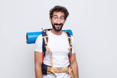 Genç adam mutlu ve şapşal görünüyor. Geniş, eğlenceli, deli gülüşü ve gözleri açık.