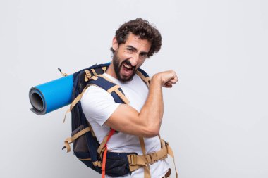 Genç adam kendini mutlu, tatmin olmuş ve güçlü hissediyor, kaslı ve formda, spor salonundan sonra güçlü görünüyor.