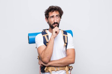 Genç adam düşünceli, meraklı ya da hayal kuruyor, hayal kuruyor ve uzayı kopyalamak için yukarı bakıyor.