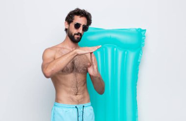 Genç adam ciddi, sert, kızgın ve hoşnutsuz görünüyor.