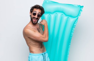 Genç adam mutlu, pozitif ve başarılı hissediyor, bir meydan okumayla karşılaştığında motive oluyor veya iyi sonuçları kutluyor.