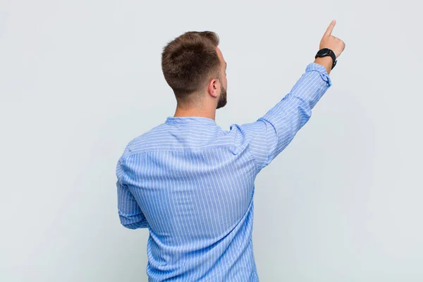 Jongeman Staand Wijzend Naar Object Kopieerruimte Achteraanzicht — Stockfoto