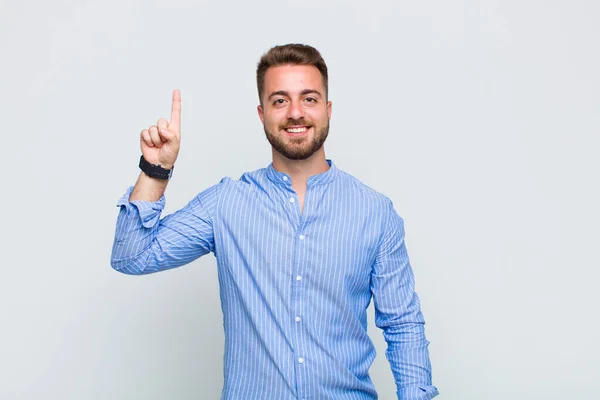 Joven Sonriendo Alegre Felizmente Apuntando Hacia Arriba Con Una Mano — Foto de Stock