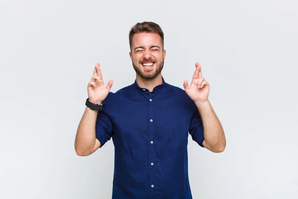 Joven Sonriendo Ansiosamente Cruzando Ambos Dedos Sintiéndose Preocupado Deseando Esperando —  Fotos de Stock