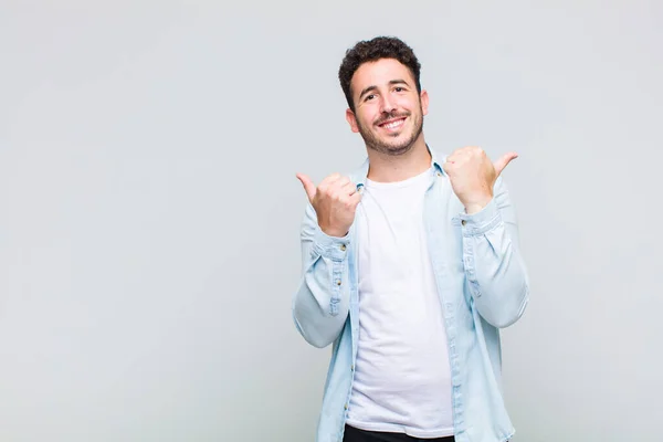 Giovane Uomo Sorridente Gioiosamente Guardando Felice Sentendosi Spensierato Positivo Con — Foto Stock