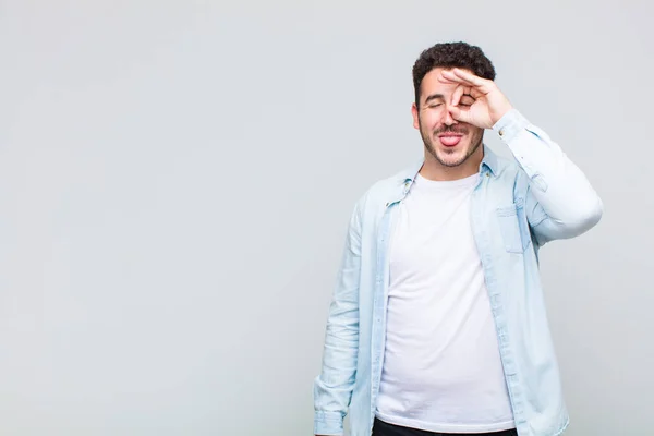 Jovem Sorrindo Feliz Com Cara Engraçada Brincando Olhando Através Espião — Fotografia de Stock