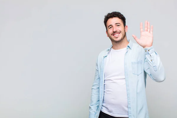 Junger Mann Lächelt Glücklich Und Fröhlich Winkt Mit Der Hand — Stockfoto