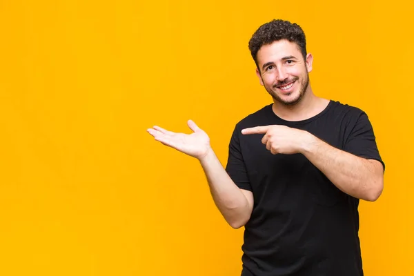 Jovem Sorrindo Alegremente Apontando Para Copiar Espaço Palma Mão Lado — Fotografia de Stock