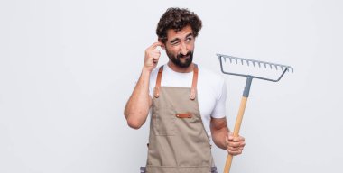 Genç adam sinirli, stresli ve sinirli görünüyor, iki kulağını da sağır edici bir ses, ses ya da yüksek sesle kapatıyor.