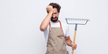 Genç adam stresli ve endişeli, depresif ve hayal kırıklığına uğramış hissediyor, iki elini de başa kaldırıyor.