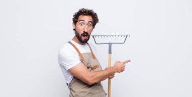 Delikanlı şaşkın ve şaşırmış hissediyor. Kenardaki fotokopi alanını işaret ediyor. Şaşırmış ve ağzı açık bakıyor.