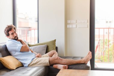 Genç adam yorgun, stresli, endişeli, hayal kırıklığına uğramış ve depresyonda, sırtı ya da boynu ağrıyan