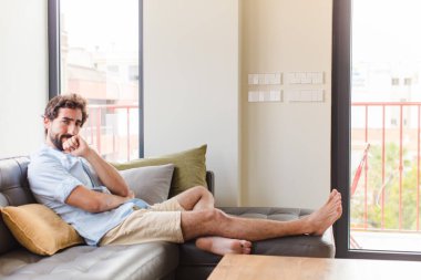 Genç adam ciddi görünüyor, kafası karışık, kararsız ve düşünceli, seçenekler ve seçimler arasında şüpheci.