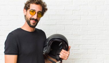 Genç adam neşeli bir şekilde gülümsüyor. Olumlu, mutlu, kendinden emin ve rahat bir ifadeyle.