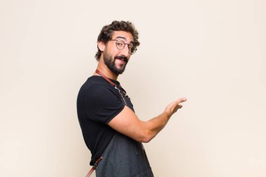 Genç adam kendini mutlu ve neşeli hissediyor, gülümsüyor ve seni hoş karşılıyor, seni dostça bir jestle içeri davet ediyor.