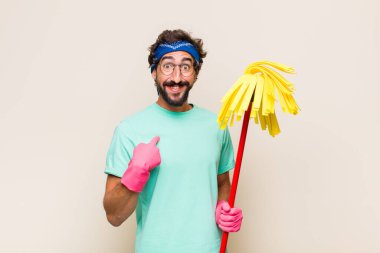 Genç adam mutlu, şaşkın ve gururlu, heyecanlı, şaşkın bakışlarla kendini işaret ediyor.