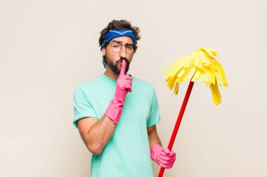 Genç adam ciddi görünüyor ve parmaklarını dudaklarına bastırıp sessizlik ya da sessizlik talep ediyor, sır saklıyor.