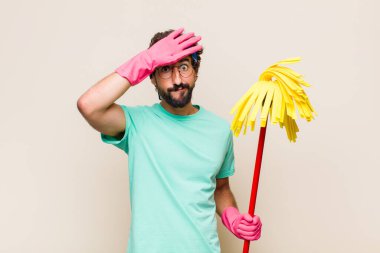 Genç adam stresli, yorgun ve hayal kırıklığına uğramış görünüyor, alnından ter damlıyor, umutsuz ve bitkin hissediyor.