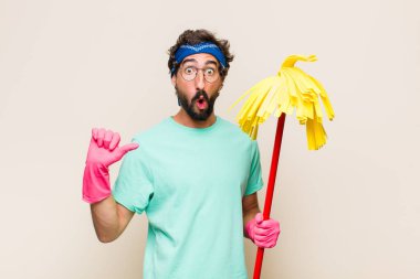 Genç adam inançsızlıktan şaşkın şaşkın bakıyor, yan taraftaki objeyi işaret ediyor ve diyor ki: