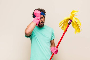 Genç adam stresli ve endişeli, depresif ve hayal kırıklığına uğramış hissediyor, iki elini de başa kaldırıyor.