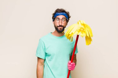 Genç adam şapşal ve komik görünüyor. Şaşı bakışlı, şakacı ve şakacı.