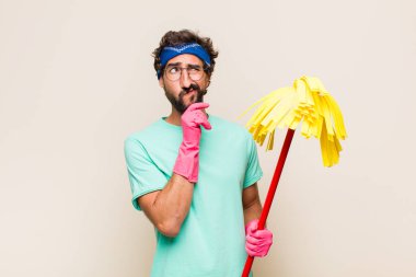 Genç adam düşünüyor, kuşkulu ve şaşkın hissediyor, farklı seçeneklerle, hangi kararı vereceğini merak ediyor.