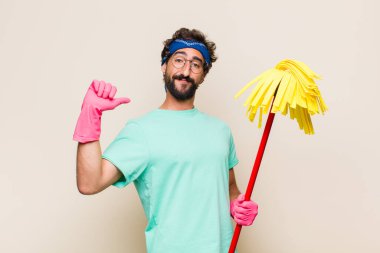 Genç adam gururlu, kibirli ve kendinden emin, tatmin olmuş ve başarılı görünüyor, kendini işaret ediyor.