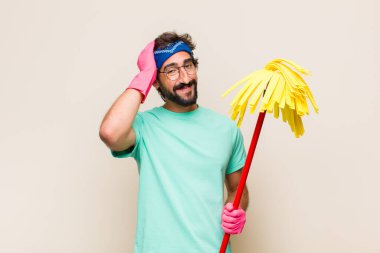 Genç adam neşeli ve sıradan bir şekilde gülümsüyor, olumlu, mutlu ve kendinden emin bir bakışla göğüs göğüse geliyor.