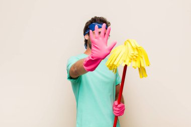 Genç adam yüzünü eliyle kapatıyor ve kamerayı durdurmak için diğer elini öne koyuyor, fotoğraf ya da resimleri reddediyor.