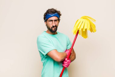 Genç adam mutsuz ve hayal kırıklığına uğramış, ciddi görünüyor, sinirlenmiş ve kollarını kavuşturmuş.