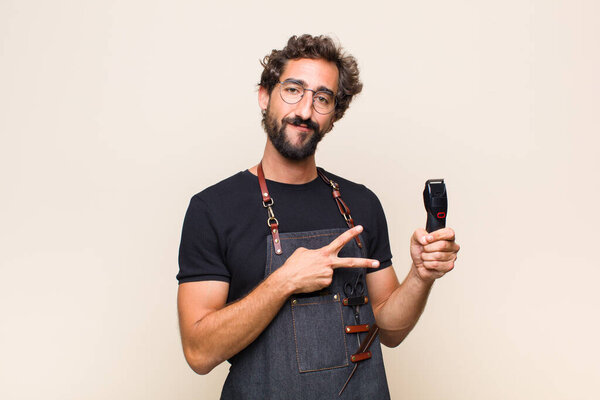 Молодой человек чувствует себя счастливым, позитивным и успешным, с руки делает V форму над грудью, показывая победу или мир