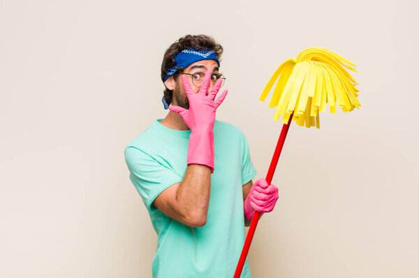 Молодой человек чувствует себя испуганным или смущенным, подглядывает или шпионит с глазами, наполовину покрытыми руками