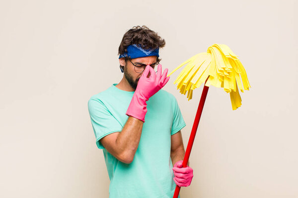 Молодой человек испытывает стресс, недовольство и разочарование, трогает лоб и страдает мигренью от сильной головной боли