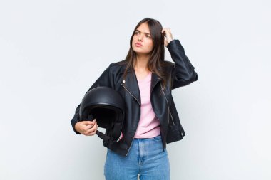 Güzel kadın şaşkın ve kafası karışmış hissediyor, başını kaşıyor ve yan tarafa bakıyor.