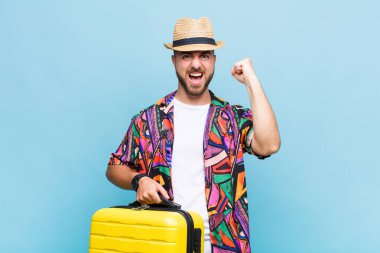 Genç adam öfkeli bir ifadeyle ya da yumruklarıyla başarıyı kutlarken agresif bir şekilde bağırıyor.