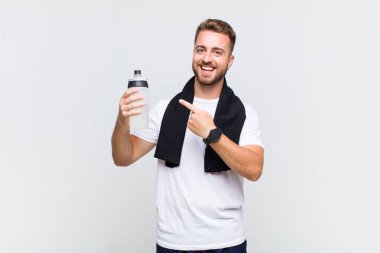 Genç adam heyecanlı ve şaşırmış görünüyor. Yana ve yukarıya doğru uzayı gösteriyor.