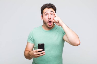 Genç adam şaşırmış, ağzı açık, şok olmuş, yeni bir düşünce, fikir ya da konsept keşfediyor.