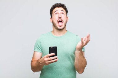 Genç adam umutsuz ve hayal kırıklığına uğramış görünüyor, stresli, mutsuz ve sinirli, bağırıyor ve çığlık atıyor.