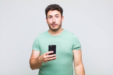 young man feeling puzzled and confused, with a dumb, stunned expression looking at something unexpected