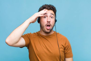 Genç adam mutlu, şaşkın ve şaşırmış görünüyor, gülümsüyor ve inanılmaz ve inanılmaz iyi haberleri fark ediyor.