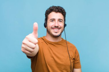 Genç adam gururlu, kaygısız, kendinden emin ve mutlu, olumlu gülümsüyor.