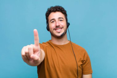 Genç adam gururla gülümsüyor ve gururla bir numaralı pozunu veriyor, kendini lider gibi hissediyor.